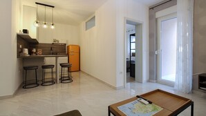 A modern kitchen with a refrigerator, bar stools, and pendant lighting. - Apartment 2355/115856 (Istria - Peroj), 1250m from the beach (Peroj)
