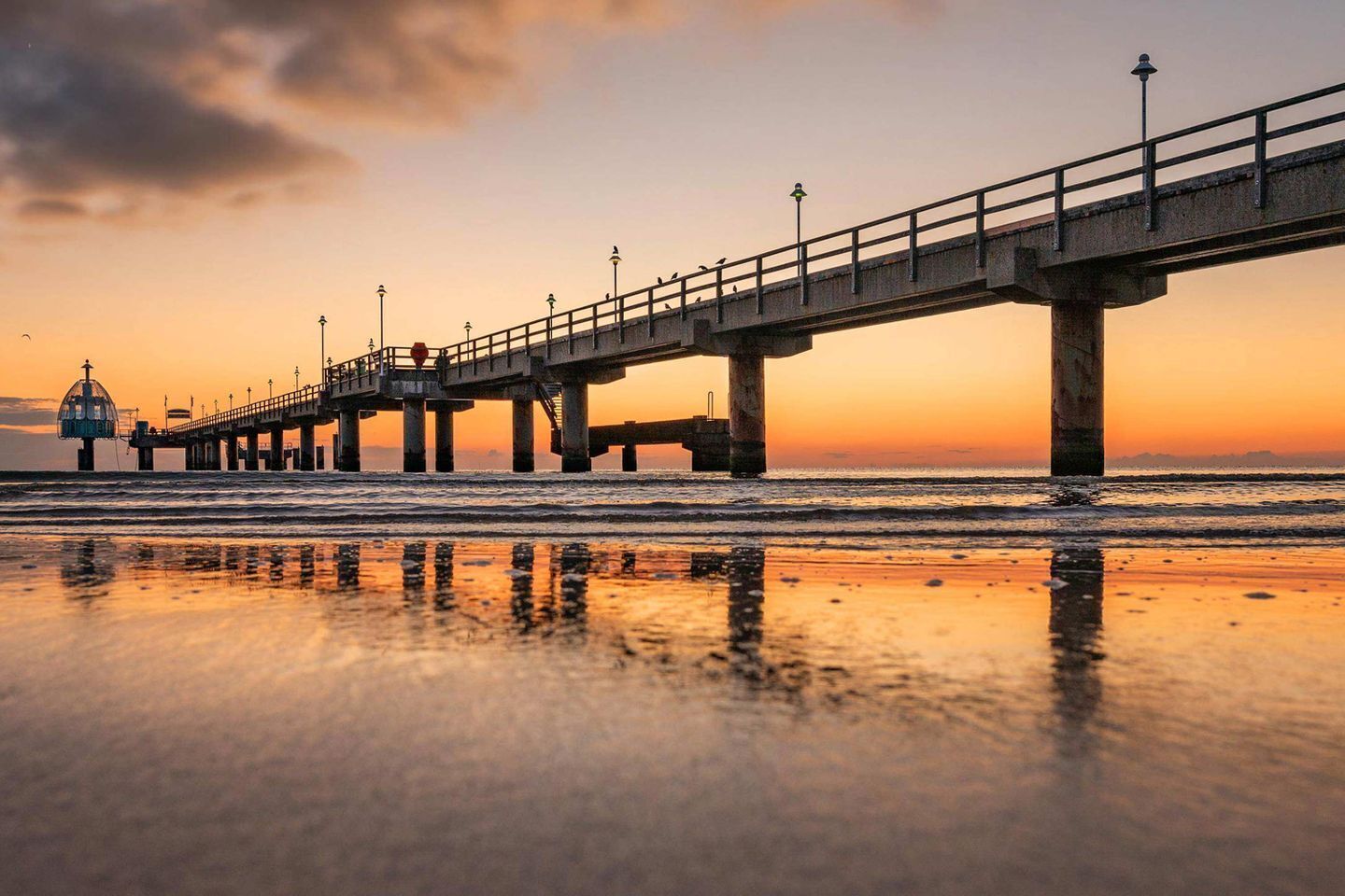 A pier extending into the water with a clear sky above.