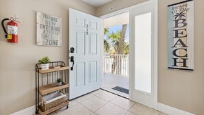 A hallway with a white door labeled '215', a fire extinguisher, a sign saying 'You are not entering a free zone', and a 'Escape to the Beach' sign.