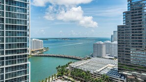 A high-rise hotel with a view of the water and a bridge. - ICON Brickell Miami- 2 bedroom Condo with City and water views! (Miami)