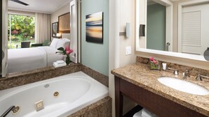 Un baño de hotel con una bañera grande, un lavabo y un espejo.
