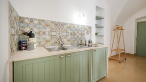 Una cocina con salpicadero estampado, un fregadero y una escalera de madera.