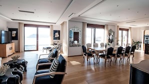 Amplia sala de estar con comedor, televisor y vistas al exterior.