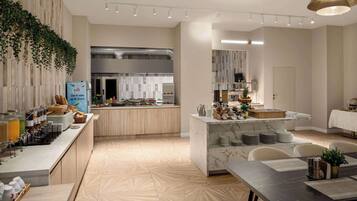 A modern kitchen with a marble island, wooden cabinets, and a breakfast bar.