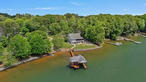 Une propriété au bord du lac comprenant une maison, un quai et un petit pavillon.