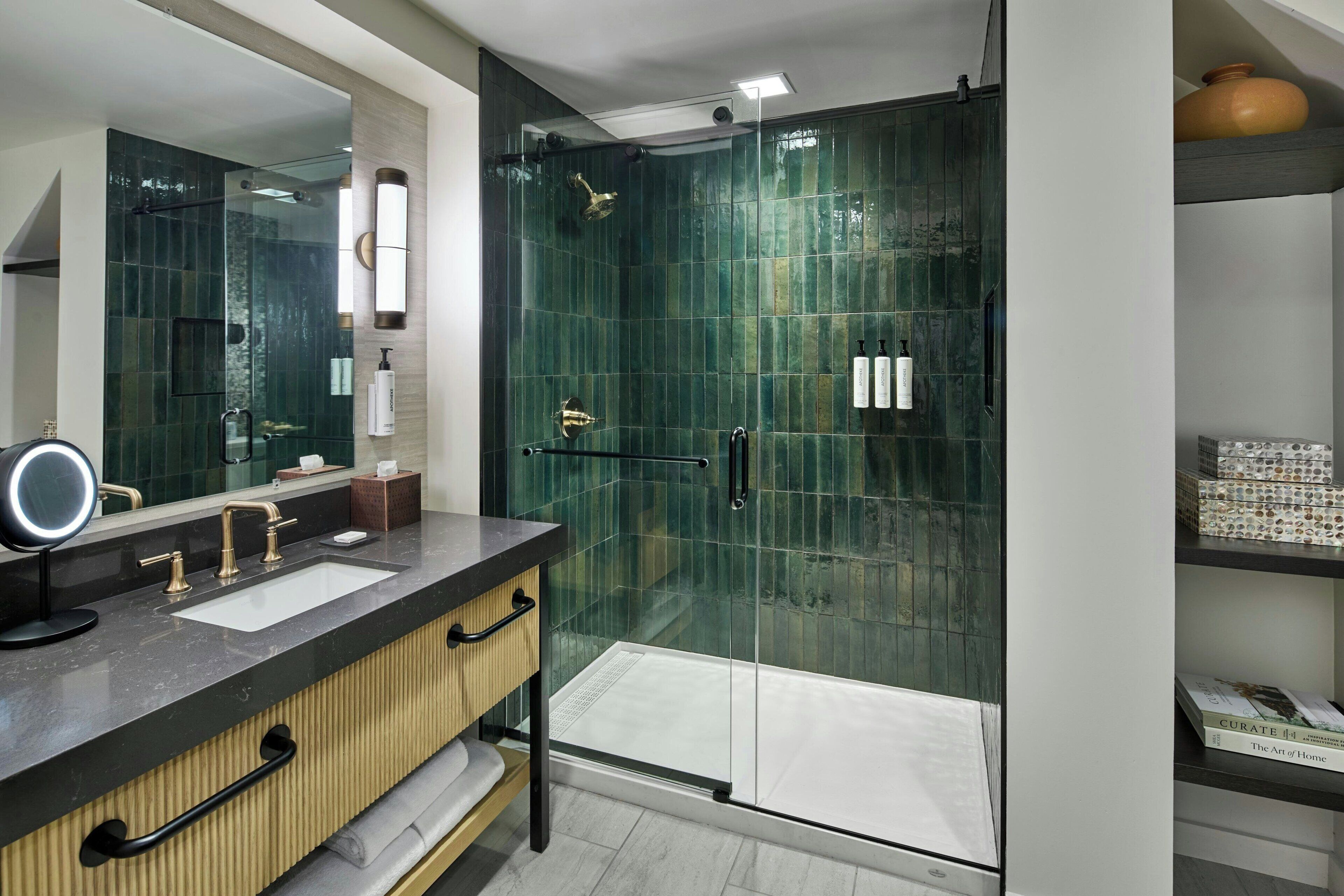 Une salle de bain moderne avec une douche à parois de verre, un meuble-lavabo avec un miroir et une étagère pour les articles de toilette.