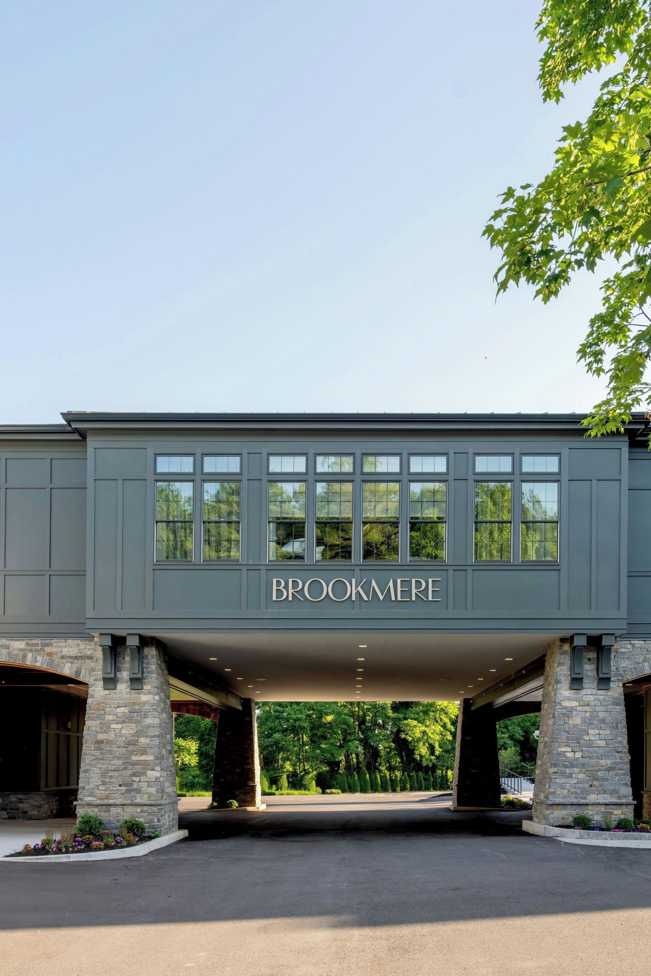 A building with a sign reading 'BROOKMERE' under a covered entrance.