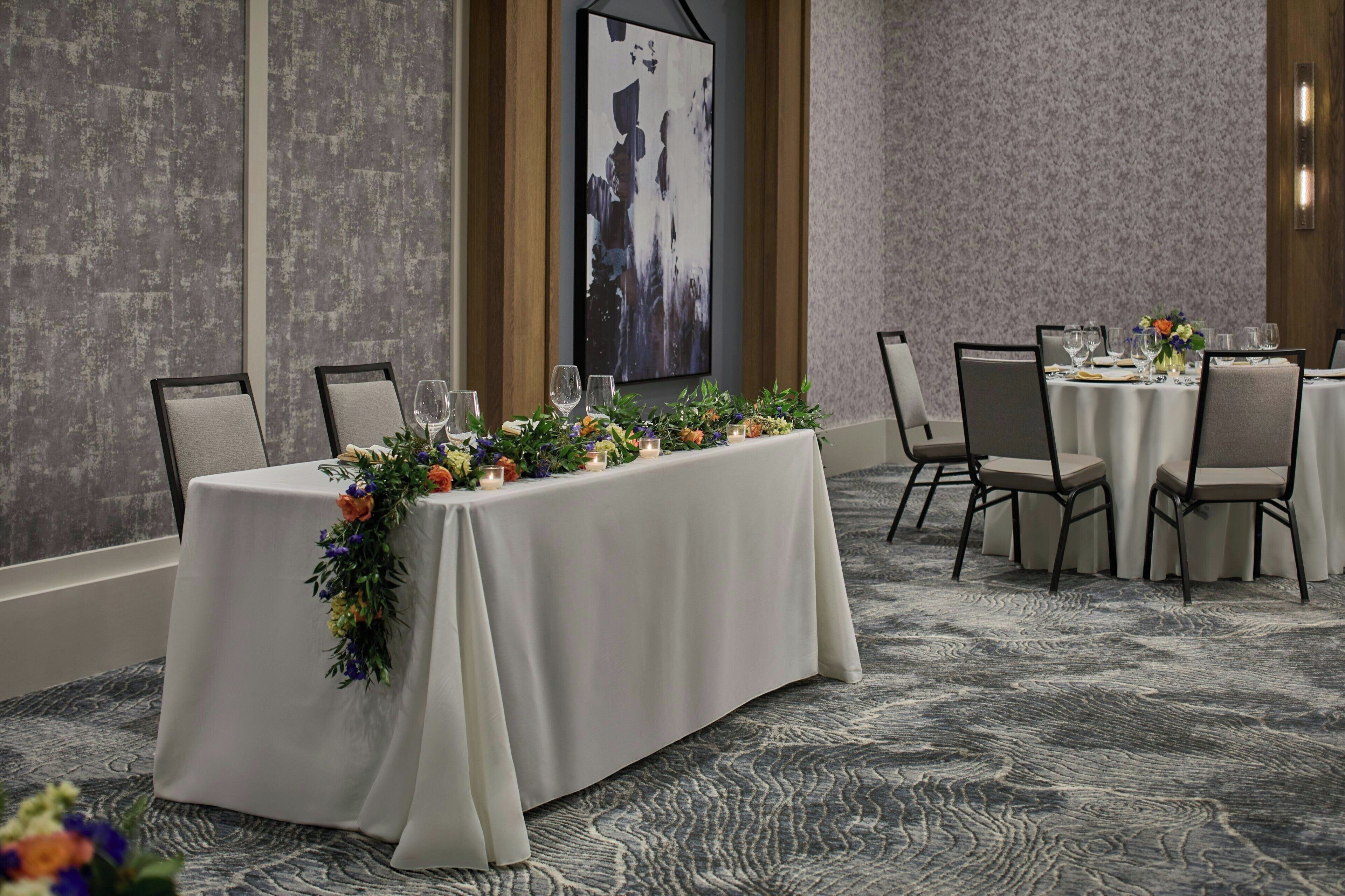 A conference room with a long table set for a meeting, surrounded by chairs.