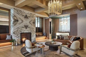 A modern living room with a fireplace, seating area, and a chandelier. - Brookmere Saratoga, a Tribute Portfolio Hotel  (Saratoga Springs)