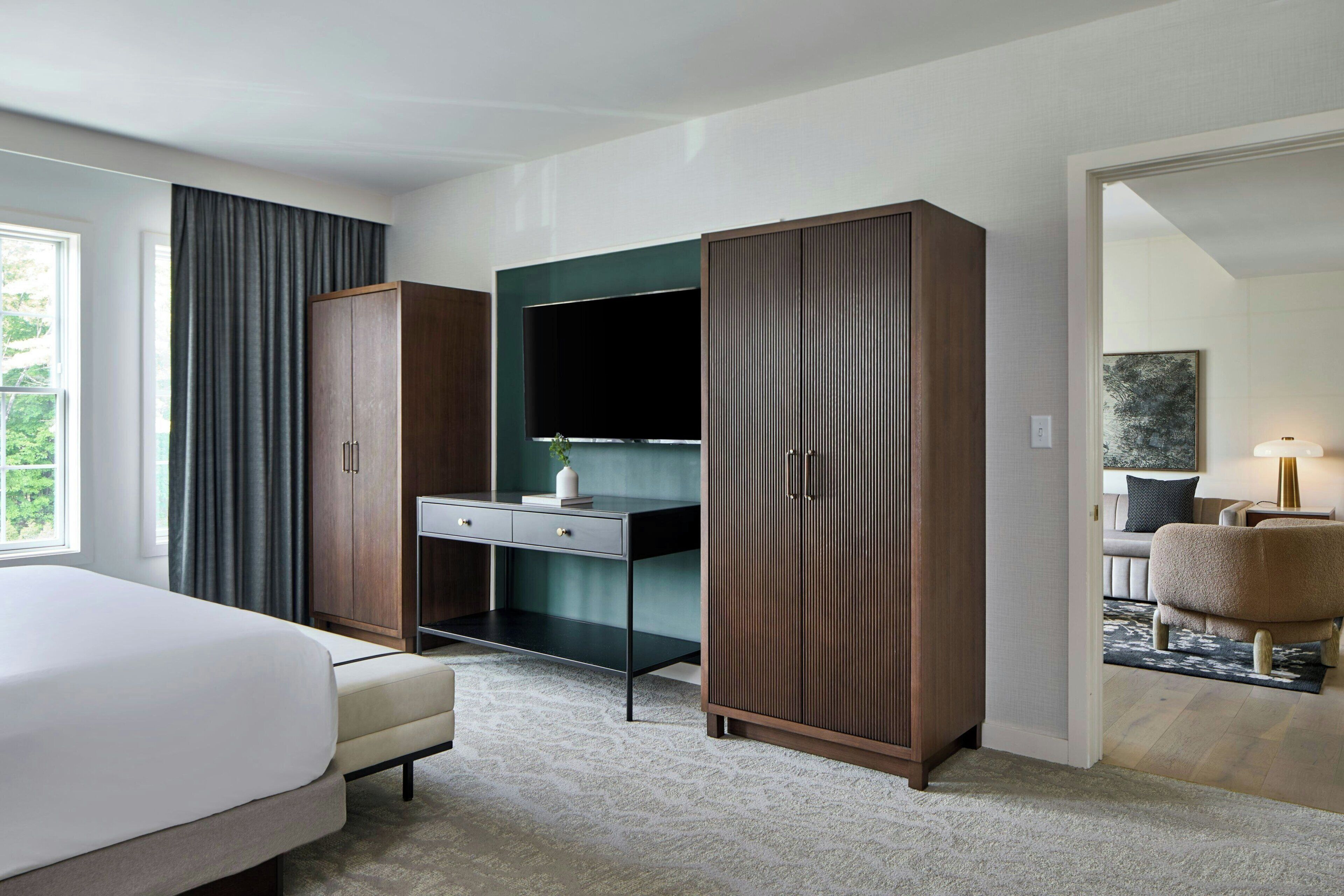 Una habitación de hotel moderna con cama, escritorio, armario y televisor.