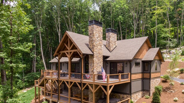 A cabin with a stone chimney, wooden deck, and multiple balconies. - On Mountain Time at Eagles Nest - single level w/hot tub, views, firepit (Banner Elk)