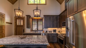 A kitchen with a large island, stainless steel appliances, and wooden cabinets. - On Mountain Time at Eagles Nest - single level w/hot tub, views, firepit (Banner Elk)