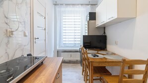 A compact kitchen with a stove, dining table, and chairs.