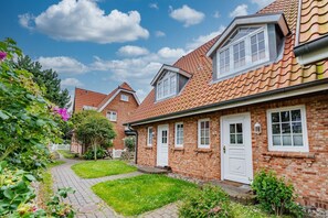 A row of brick houses with red-tiled roofs, white doors, and windows. - Meeresleuchten - Ab 2025 bei uns im Angebot, für Max. 4 Personen (Sylt)