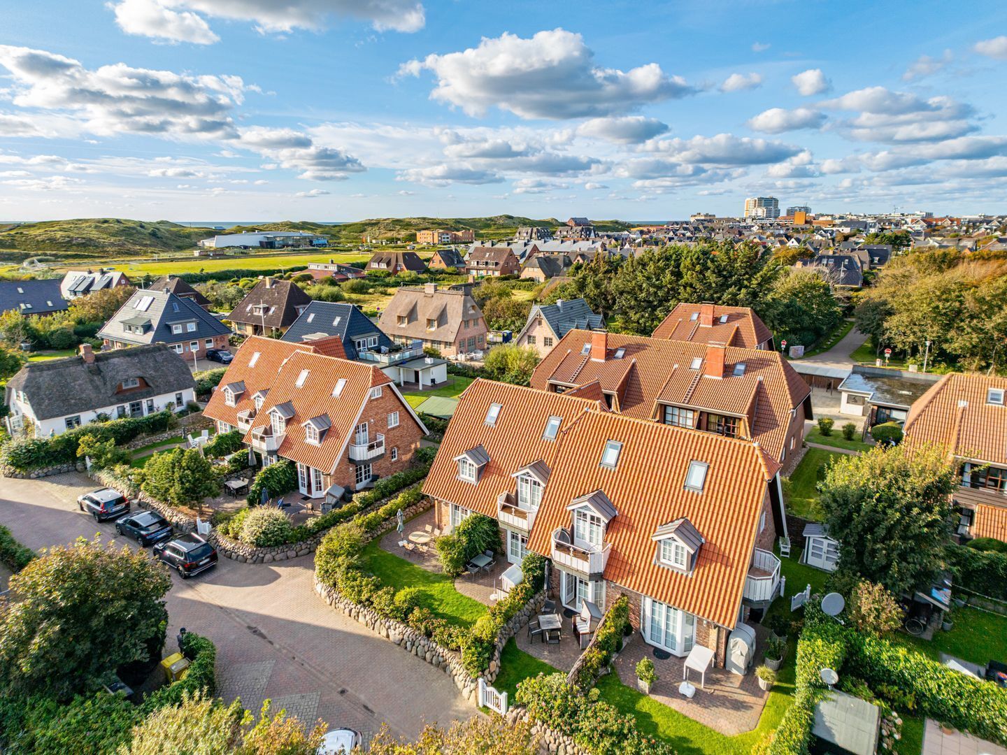 A residential area with houses featuring red-tiled roofs and brick exteriors.