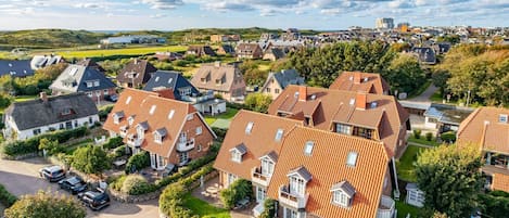A residential area with houses featuring red-tiled roofs and brick exteriors.