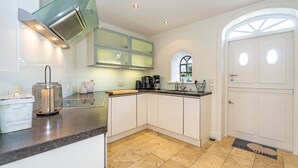 A modern kitchen with a built-in stove, a coffee maker, and a window with a view.