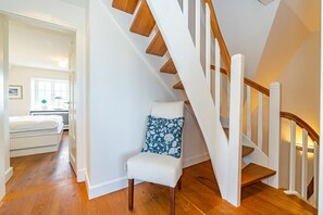 Eine Treppe mit Holzdielen und weißen Geländern, die zu einer oberen Etage führt.