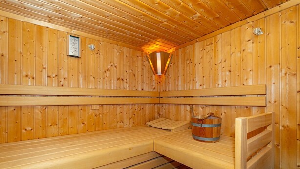 A wooden sauna with benches and a bucket. - Hüs bi Koog 1 - Vacation under thatch for up to 5 people. (Sylt)