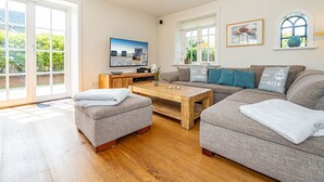 A modern living room with a sofa set, a coffee table, and a TV. - Hüs bi Koog 1 - Vacation under thatch for up to 5 people. (Sylt)