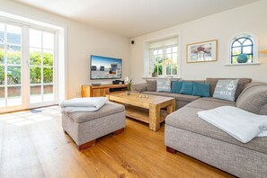 A modern living room with a sofa set, a coffee table, and a TV. - Hüs bi Koog 1 - Vacation under thatch for up to 5 people. (Sylt)