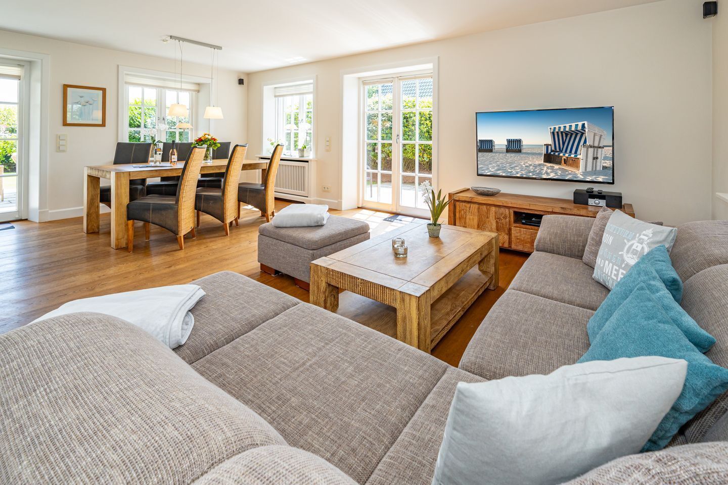 Ein geräumiges Wohnzimmer mit großem Sofa, Couchtisch und Essbereich mit Tisch und Stühlen.