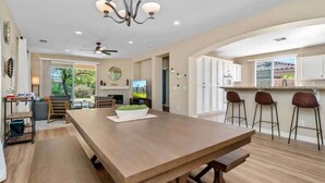A spacious kitchen with a large island, bar stools, and a view of the outdoors. - Lake View 3BR | Resort Pools at Indian Palms (Indio)