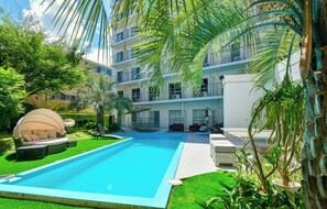 A modern hotel with a swimming pool, outdoor seating, and lush greenery. - Executive Suite vs | Room only Parking availab / Fukuoka Fukuoka (Fukuoka)
