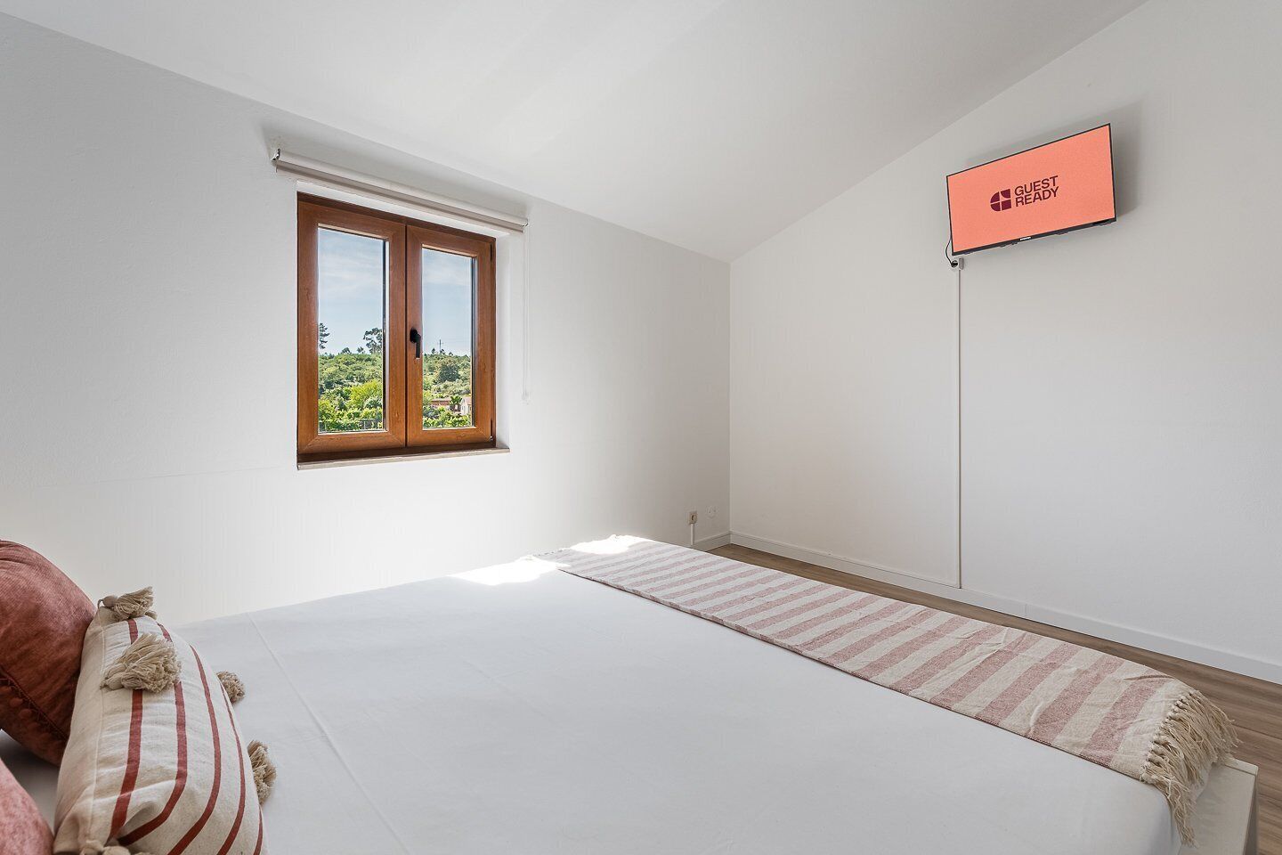 Habitación de hotel con cama, ventana con vistas, televisor de pantalla plana y alfombra.