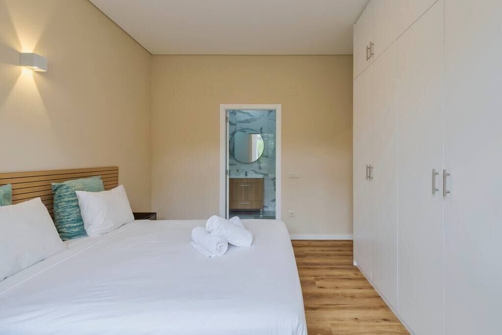 Une chambre à coucher avec un lit, une armoire et une porte donnant sur la salle de bain.