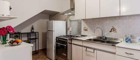 Een koelkast, een microgolfoven, een oven, kookgerei, borden en bestek