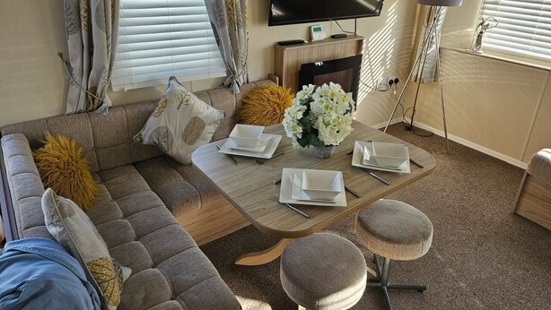 A living room with a sofa, a coffee table, and a TV. - 3 Bed Caravan - Sleeps 6 - Pets - Parking - Wifi (Skegness)