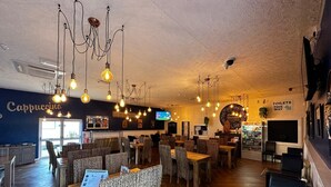 A cozy restaurant with hanging light fixtures, a bar area, and a visible menu board. - 3 Bed Caravan - Sleeps 6 - Pets - Parking - Wifi (Skegness)