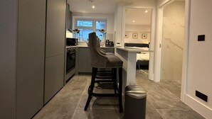 Et moderne køkken med en central ø, et barområde og et siddeområde.