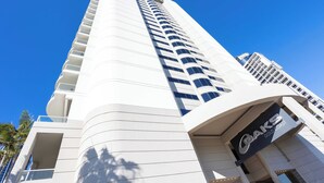 A tall, modern hotel with a curved facade and a prominent sign for "OAKS GOLD COAST". - Surfers Paradise Studio with Ocean Views (Surfers Paradise)