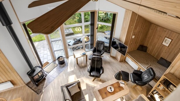 Een modern interieur met een plafondventilator, een open haard en uitzicht op het buitenterras.