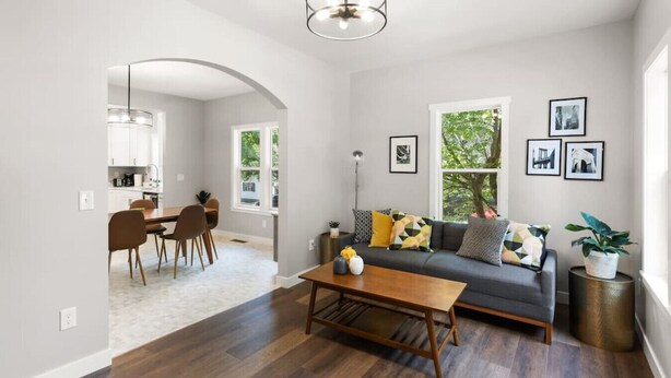 A modern living room with a sofa, coffee table, and dining area. - Mid-Century Connection | Nestled Amid Universities (Sioux Falls)
