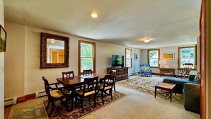 A spacious living room with a dining area, a television, and a sofa. - High Street Haven, steps to Camden Harbor (Camden)