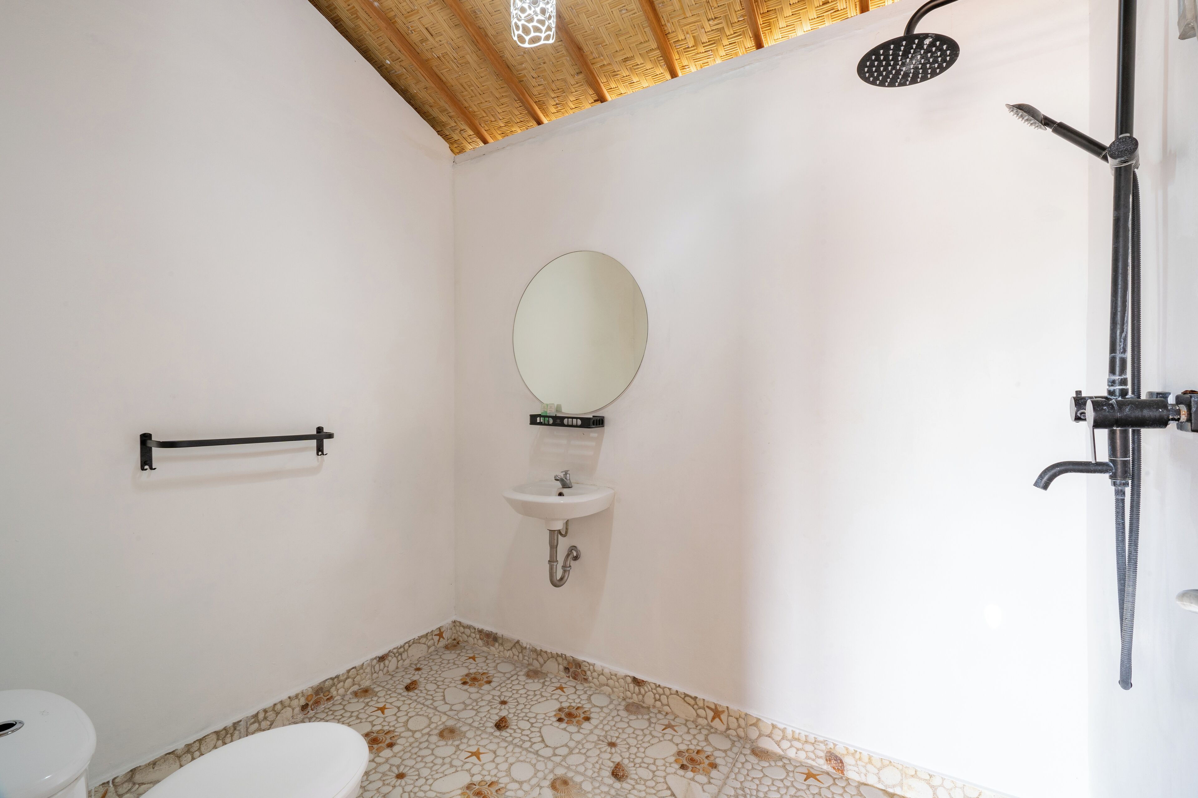 Een badkamer met toilet, wastafel, spiegel en douche.