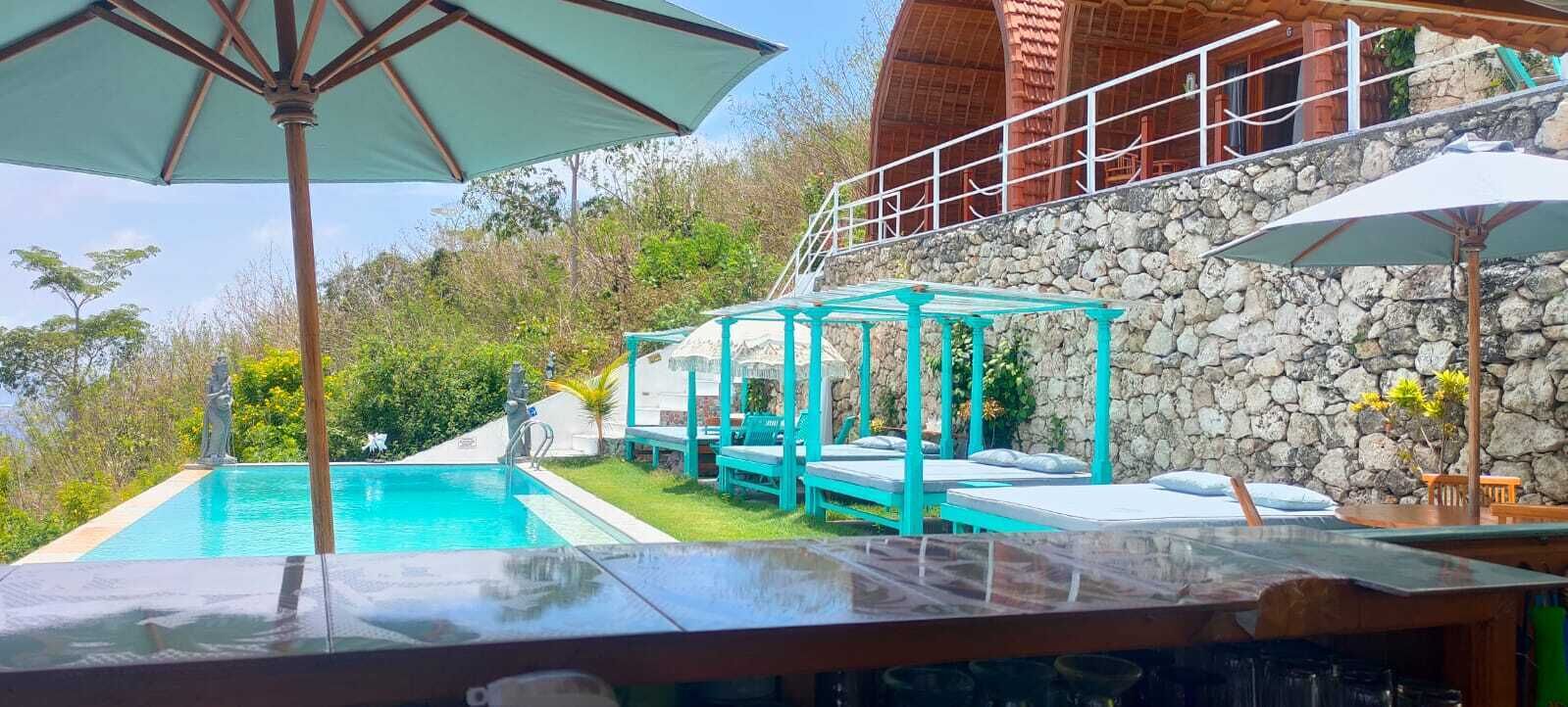 Una piscina amb terrassa de fusta i una glorieta.