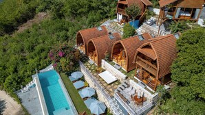 Un resort con varias villas de madera, una piscina y zonas de estar al aire libre.