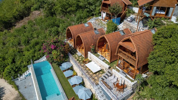 A resort with multiple wooden villas, a swimming pool, and outdoor seating areas. - Butterfly Villas Nusa Ceningan (Ceningan Island)