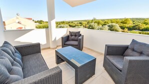 A covered outdoor seating area with wicker furniture and a tiled floor. - Apartment Zubčić by Interhome (Sv. Filip i Jakov)