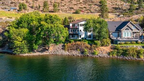 Una propiedad frente al lago con dos casas, una con balcón y otra con una terraza amplia.