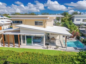 A modern two-story house with a covered patio, a swimming pool, and a well-maintained lawn. - Coastal Charm on Casuarina Way (Kingscliff)