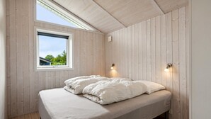 A bedroom with a wooden ceiling, a skylight, a bed with white bedding, and two wall-mounted lights. - "Tayana" - 700m from the sea by Interhome (Sydals)