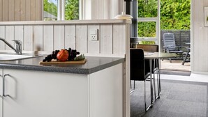 A modern kitchen with a granite countertop, a sink, and a window overlooking a garden. - "Tayana" - 700m from the sea by Interhome (Sydals)