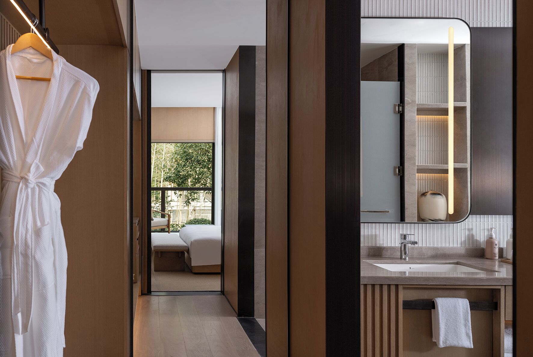 Un baño moderno con un espejo grande, un lavabo y un perchero para toallas.