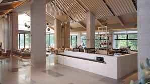 A spacious lobby with high ceilings, large windows, and a central reception desk. - Garrya Xianju (Taizhou)