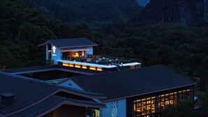 A modern building with a dining area and a view of a mountainous landscape. - Garrya Xianju (Taizhou)